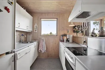 a large kitchen with white cabinets and a window at JB102-Fjerritslev-Blabaerstien-7 in Fjerritslev