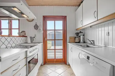 a kitchen with white appliances and a door to a patio at JB144-Frostrup-Horsbakkevej-7 in Frøstrup