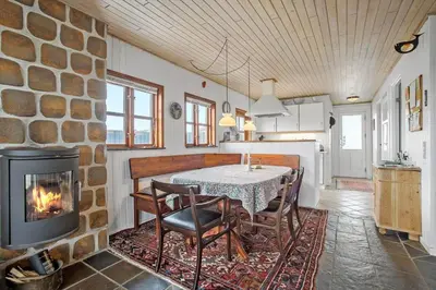 a kitchen and dining room with a table and a fireplace at JB144-Frostrup-Horsbakkevej-7 in Frøstrup