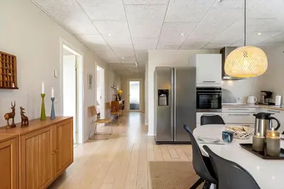 a kitchen with a dining table and a refrigerator at JB666-Fjerritslev-Aspevej-21 in Fjerritslev