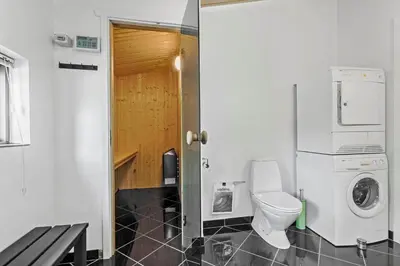 a bathroom with a toilet and a washer and dryer at JB828-Fjerritslev-Revlingestien-71 in Fjerritslev