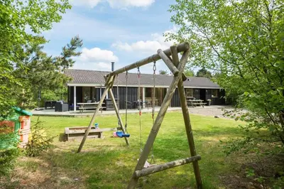 a wooden swing set in the yard of a house at JB828-Fjerritslev-Revlingestien-71 in Fjerritslev