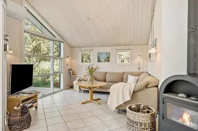 a living room with a couch and a fireplace at JB696-Fjerritslev-Blabaerstien-56 in Fjerritslev