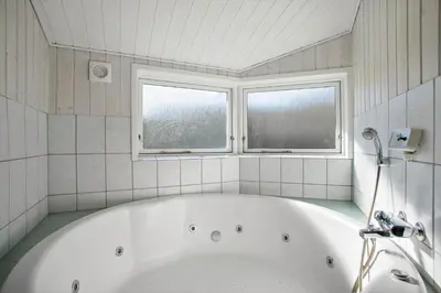 a bath tub in a bathroom with two windows at JB182-Fjerritslev-Gyvelstien-39 in Fjerritslev