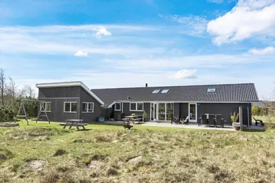 a black house with a picnic table in a yard at JB203-Brovst-Kronvildtvej-35 in Brovst