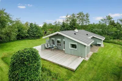a green shed with a deck in a field at JB122-Fjerritslev-Tyttebaerstien-14 in Fjerritslev
