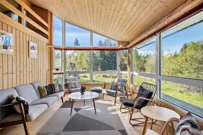 a living room with a couch and a table and chairs at JB154-Fjerritslev-Bredvandet-34 in Fjerritslev