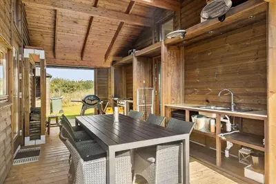 a kitchen with a table and chairs in a cabin at JB177-Fjerritslev-Aspevej-44 in Fjerritslev