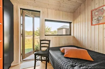 a bedroom with a bed and a chair and a window at JB177-Fjerritslev-Aspevej-44 in Fjerritslev