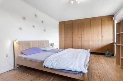 a bedroom with a large bed and wooden cabinets at JB325-Frostrup-Bulbjergvej-40 in Frøstrup