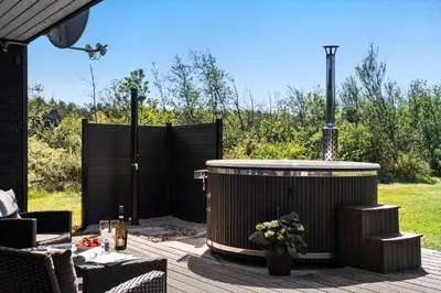 a hot tub on a patio with a fence at JB328-Brovst-Kronvildtvej-184 in Brovst