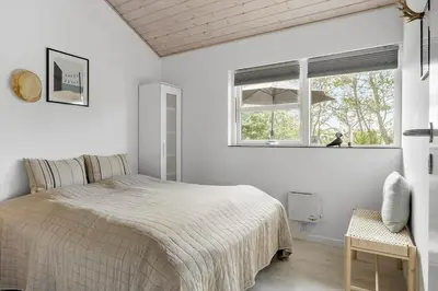 a white bedroom with a bed and a window at JB161-Brovst-Kronvildtvej-206 in Brovst