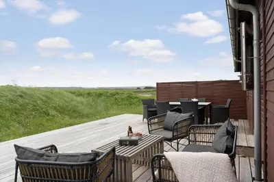 a deck with chairs and a table on a building at JB233-Brovst-Ejstrup-Strandvej-24 in Brovst