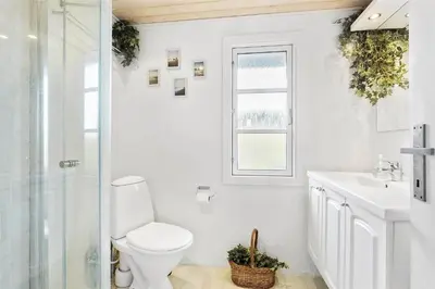 a bathroom with a toilet and a sink and a window at JB116-Frostrup-Svenstibakkevej-30 in Frøstrup