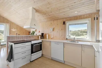 a large kitchen with white cabinets and a window at JB173-Brovst-Redningsvejen-28 in Brovst
