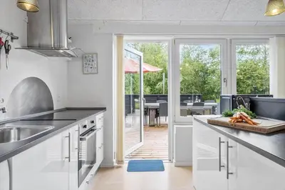 a kitchen with white cabinets and a view of a patio at JB178-Brovst-Kronvildtvej-3 in Brovst