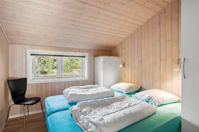 two beds in a room with wooden walls at JB133-Fjerritslev-Blabaerstien-35 in Fjerritslev