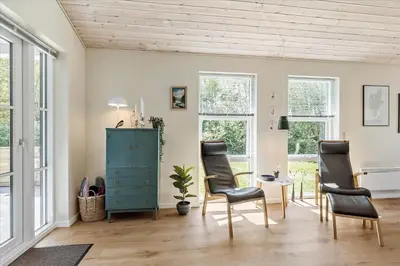 a living room with chairs and a blue cabinet at JB165-Fjerritslev-Ostersvej-16 in Fjerritslev