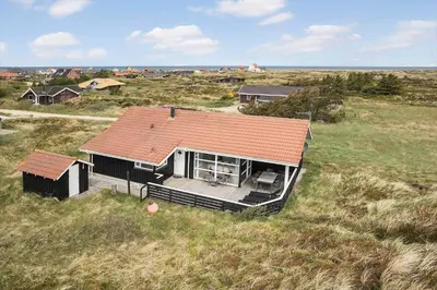 a small house with a red roof in a field at JB705-Frostrup-Svenstibakkevej-82 in Frøstrup