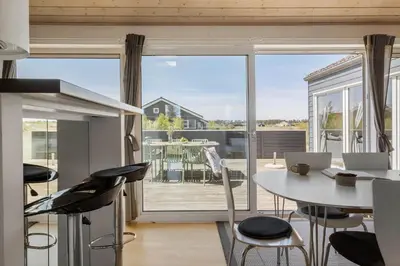 a kitchen with a table and chairs and a large window at JB327-Brovst-Kronvildtvej-140 in Brovst
