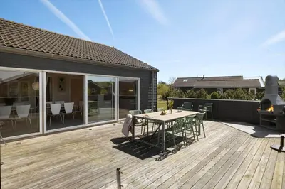 a patio with a table and chairs on a deck at JB327-Brovst-Kronvildtvej-140 in Brovst