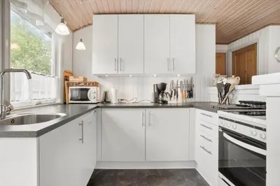 a white kitchen with white cabinets and a sink at JB205-Fjerritslev-Tyttebaerstien-12 in Fjerritslev