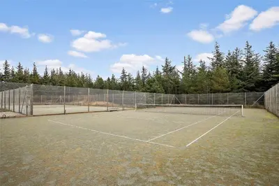 a tennis court with a net and some trees at JB628-Fjerritslev-Lynghojsletten-49 in Fjerritslev
