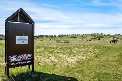 a sign in a field with horses in the distance at JB141-Brovst-Kronvildtvej-86 in Brovst