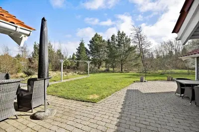 a patio with a table and chairs and a yard at JB303-Fjerritslev-Tyttebaerstien-50 in Fjerritslev