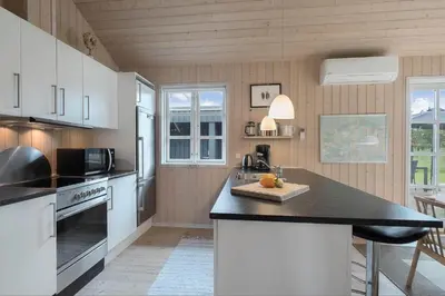 a kitchen with white cabinets and a black counter top at JB283-Frostrup-Andreas-Lassens-Vej-6 in Frøstrup