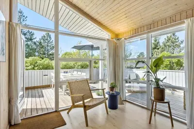 a screened in porch with a chair and a table at JB291-Fjerritslev-Stenhusvej-30 in Fjerritslev