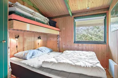 a bed in a wooden room with a window at JB391-Fjerritslev-Perikumvej-62 in Fjerritslev