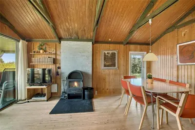 a living room with a table and a fireplace at JB391-Fjerritslev-Perikumvej-62 in Fjerritslev
