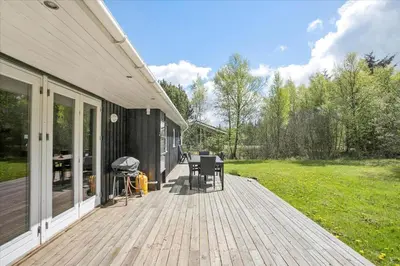 a wooden deck with chairs and a grill on a house at JB167-Fjerritslev-Revlingestien-83 in Fjerritslev