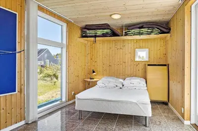 a bedroom with a bed in a room with a window at JB169-Brovst-Kronvildtvej-126 in Brovst