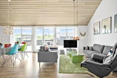 a living room with a couch and chairs and a television at JB169-Brovst-Kronvildtvej-126 in Brovst