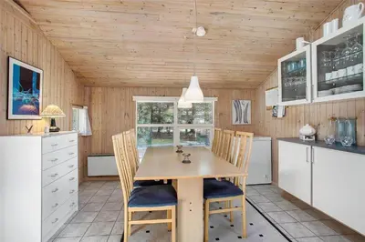 a kitchen with a wooden table and chairs at JB255-Fjerritslev-Blabaerstien-22 in Fjerritslev
