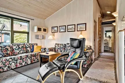 a living room with a couch and a chair at JB314-Fjerritslev-Tyttebaerstien-13 in Fjerritslev