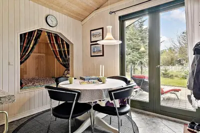 a dining room with a table and chairs and a window at JB314-Fjerritslev-Tyttebaerstien-13 in Fjerritslev