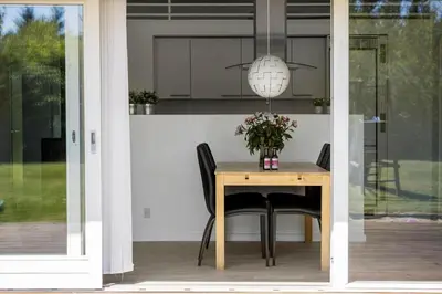 a dining room table with black chairs and a pendant light at JB221-Brovst-Kronvildtvej-182 in Brovst