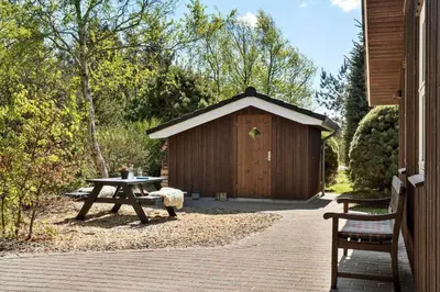 a wooden shed with a picnic table in front of it at JB251-Fjerritslev-Egevej-5 in Fjerritslev