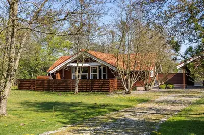 a log cabin with a porch in the woods at JB198-Fjerritslev-Tyttebaerstien-40 in Fjerritslev