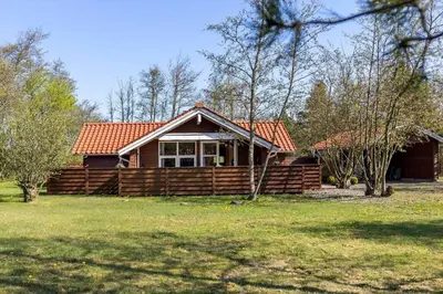a log cabin with a porch and a grass yard at JB198-Fjerritslev-Tyttebaerstien-40 in Fjerritslev