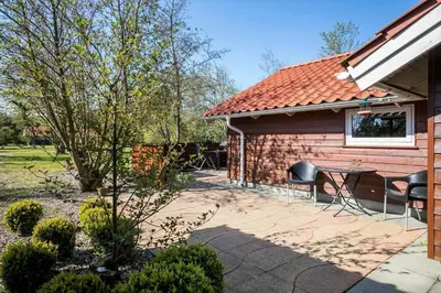 a patio with a table and chairs next to a building at JB198-Fjerritslev-Tyttebaerstien-40 in Fjerritslev