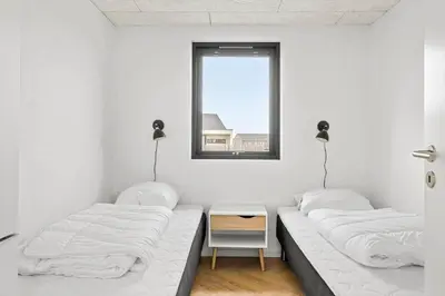 two beds in a white room with a window at JB172-Brovst-Kronvildtvej-110 in Brovst