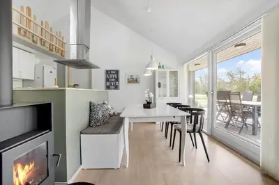 a living room with a table and a fireplace at JB752-Brovst-Kronvildtvej-210 in Brovst