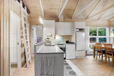 a kitchen with white appliances and a table and chairs at JB138-Fjerritslev-C-J-Thaningsvej-3 in Fjerritslev
