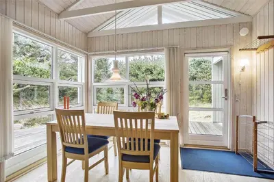 a dining room with a table and chairs and windows at JB138-Fjerritslev-C-J-Thaningsvej-3 in Fjerritslev