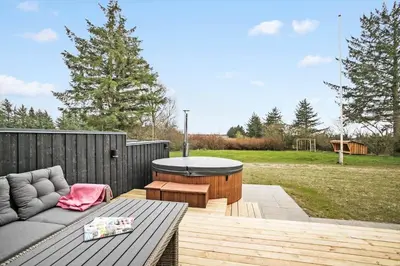 a patio with a couch and a table on a deck at JB200-Fjerritslev-Udklitvej-168 in Fjerritslev