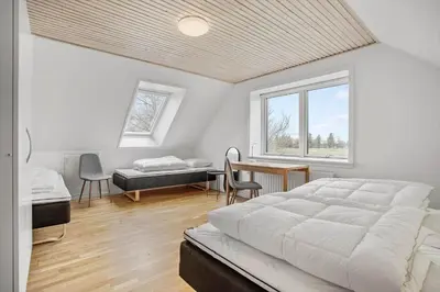 a bedroom with a large white bed and a desk at JB200-Fjerritslev-Udklitvej-168 in Fjerritslev